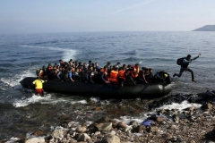 Yannis Behrakis (Reuters). 19 ottobre 2015. Un migrante afghano tocca terra saltando da un gommone pieno di profughi sull'isola di Lesbo